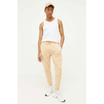 Tommy Jeans pantaloni de trening culoarea bej, cu imprimeu ieftini