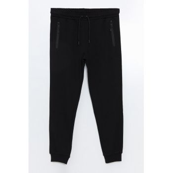 Pantaloni de trening conici cu buzunare cu fermoar