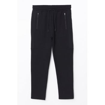 Pantaloni de trening conici cu buzunare cu fermoar